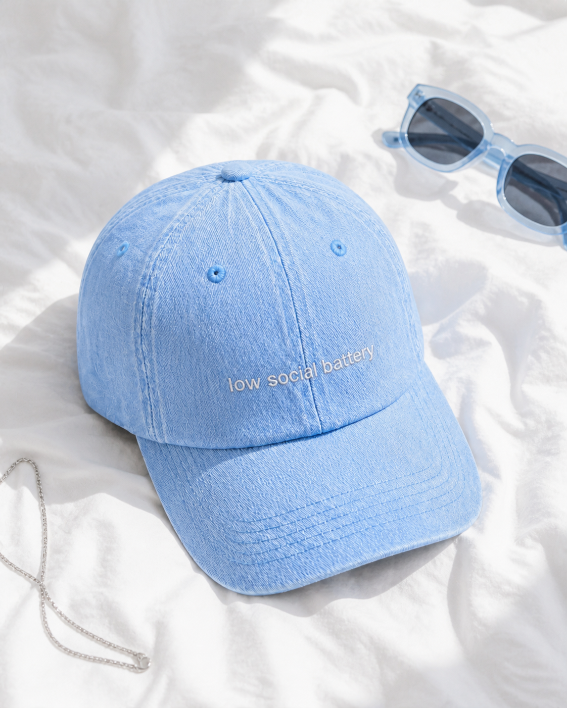 Low Social Battery cap in light blue — washed cotton dad hat with “low social battery” embroidered in white, product shot