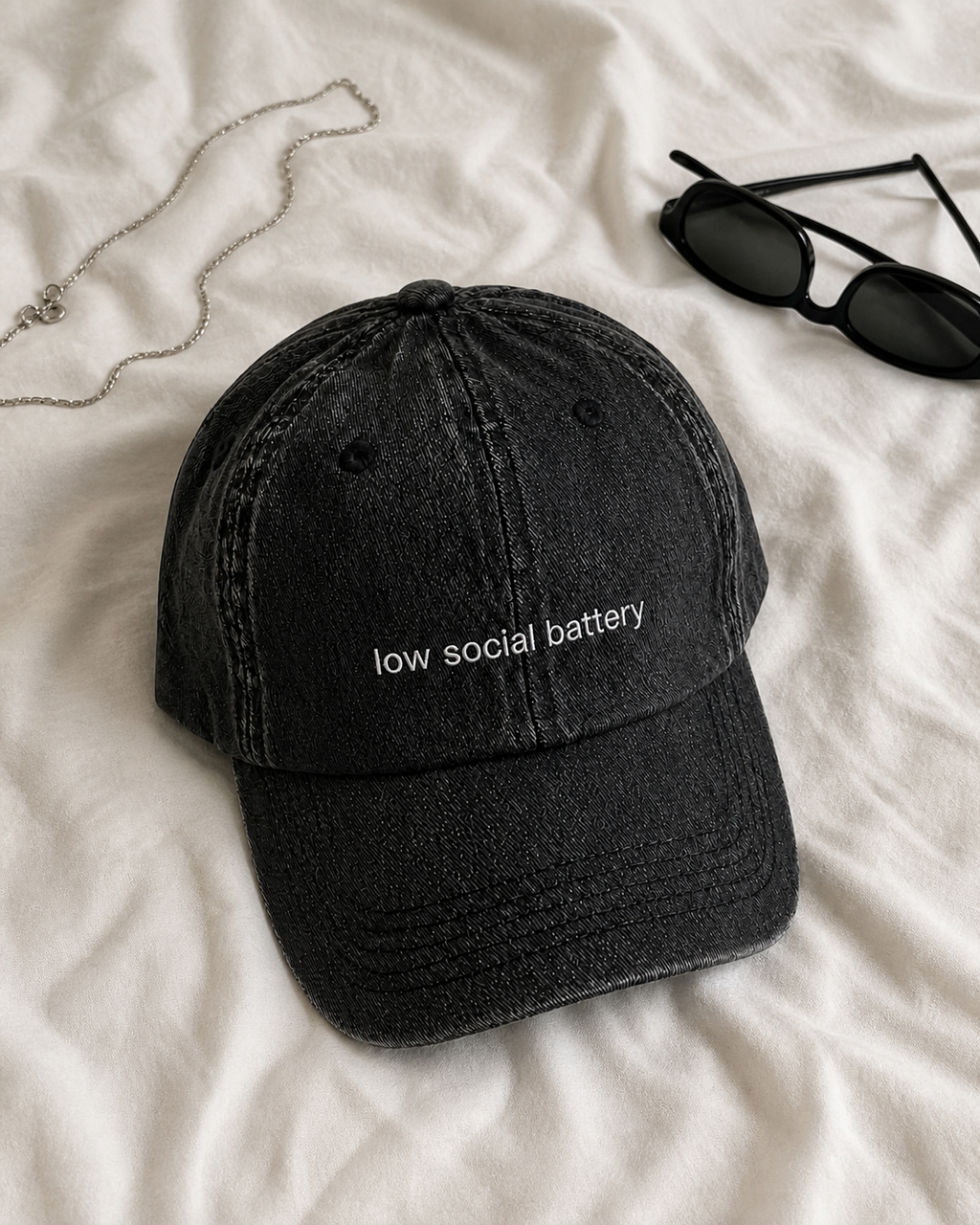 Low Social Battery cap in black — washed cotton dad hat with “low social battery” embroidered in white, product shot
