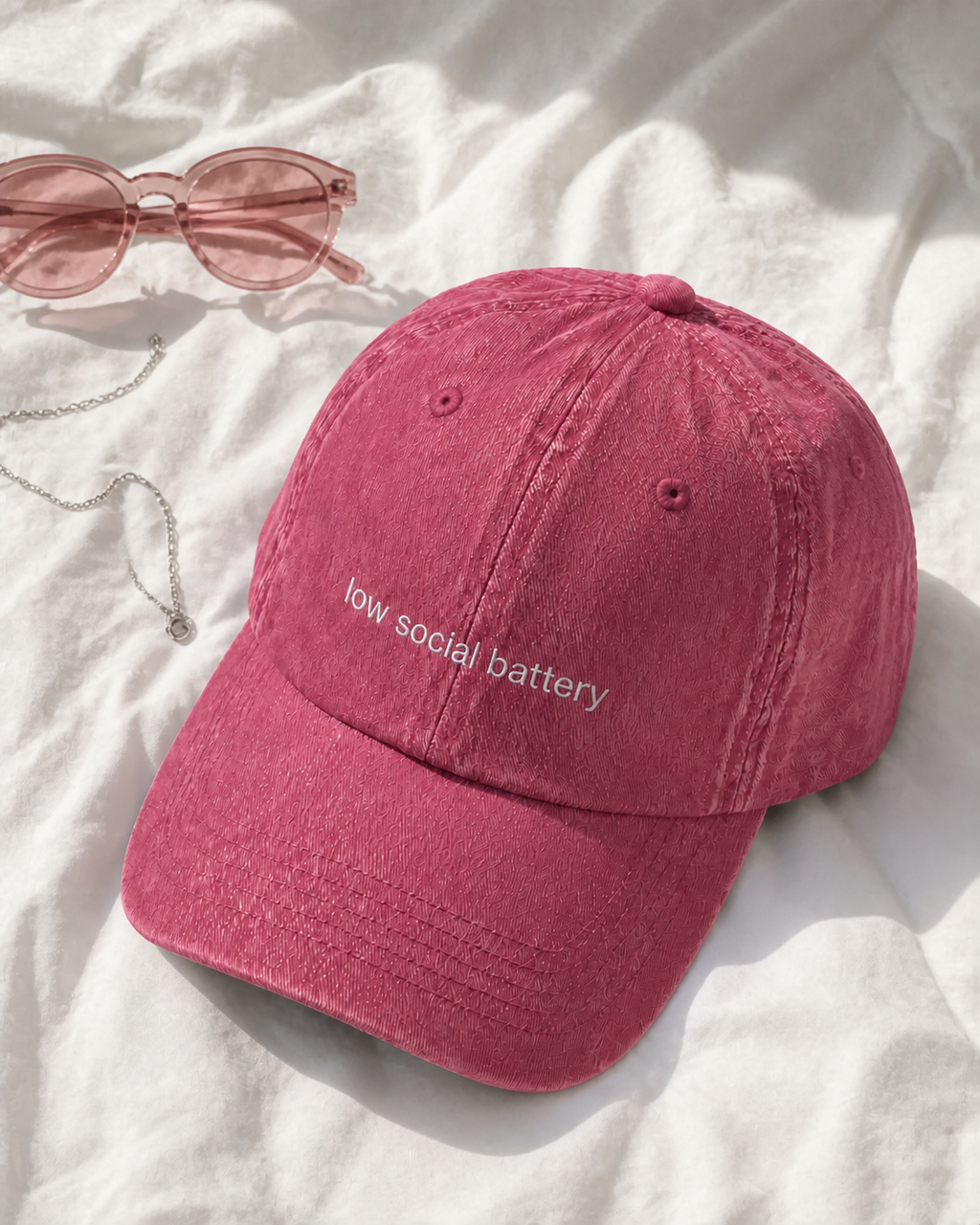 Low Social Battery cap in dark pink — washed cotton dad hat with “low social battery” embroidered in white, product shot