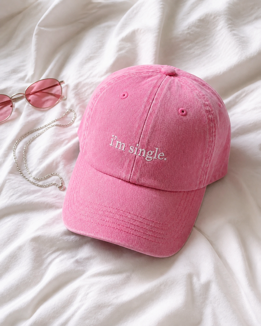 I'm Single cap in baby pink — washed cotton dad hat with “i'm single.” embroidered in white, product shot
