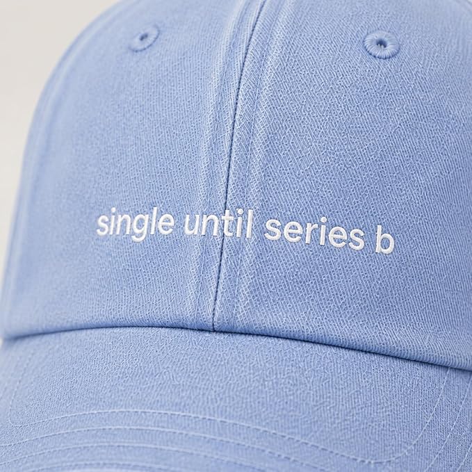 A close-up of a light blue baseball cap with white embroidered text reading 'single until series b' on the front panel.