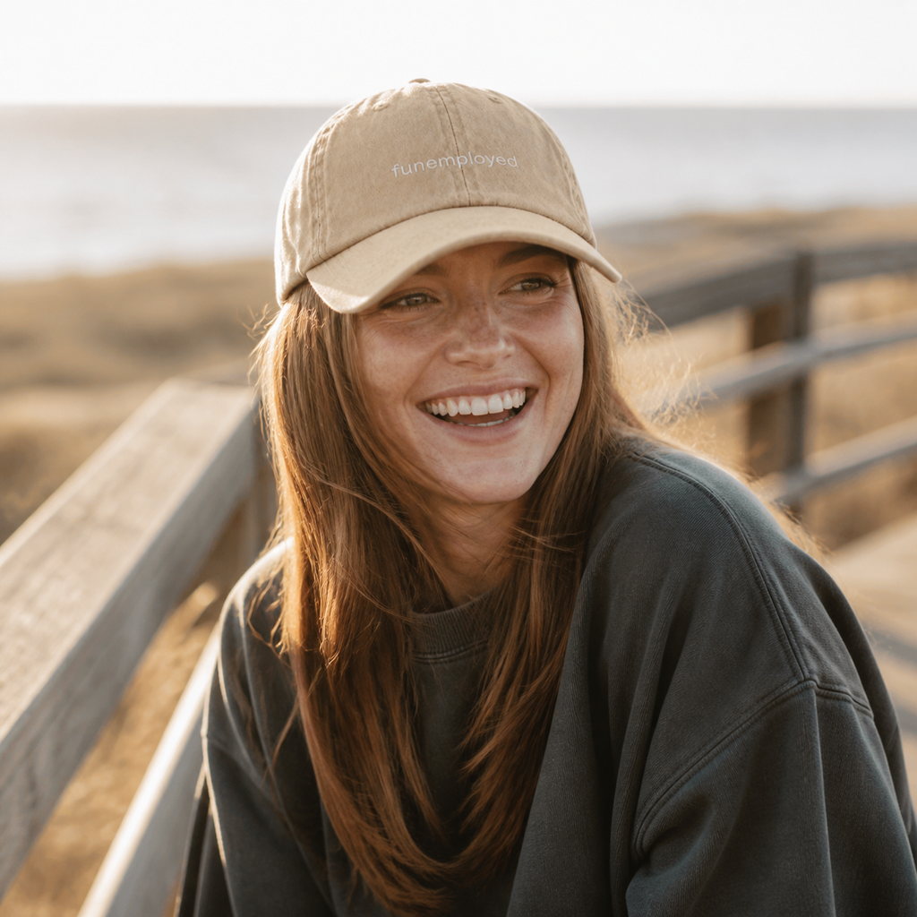 Funemployed cap in beige — washed cotton dad hat with “funemployed” embroidered in white, worn