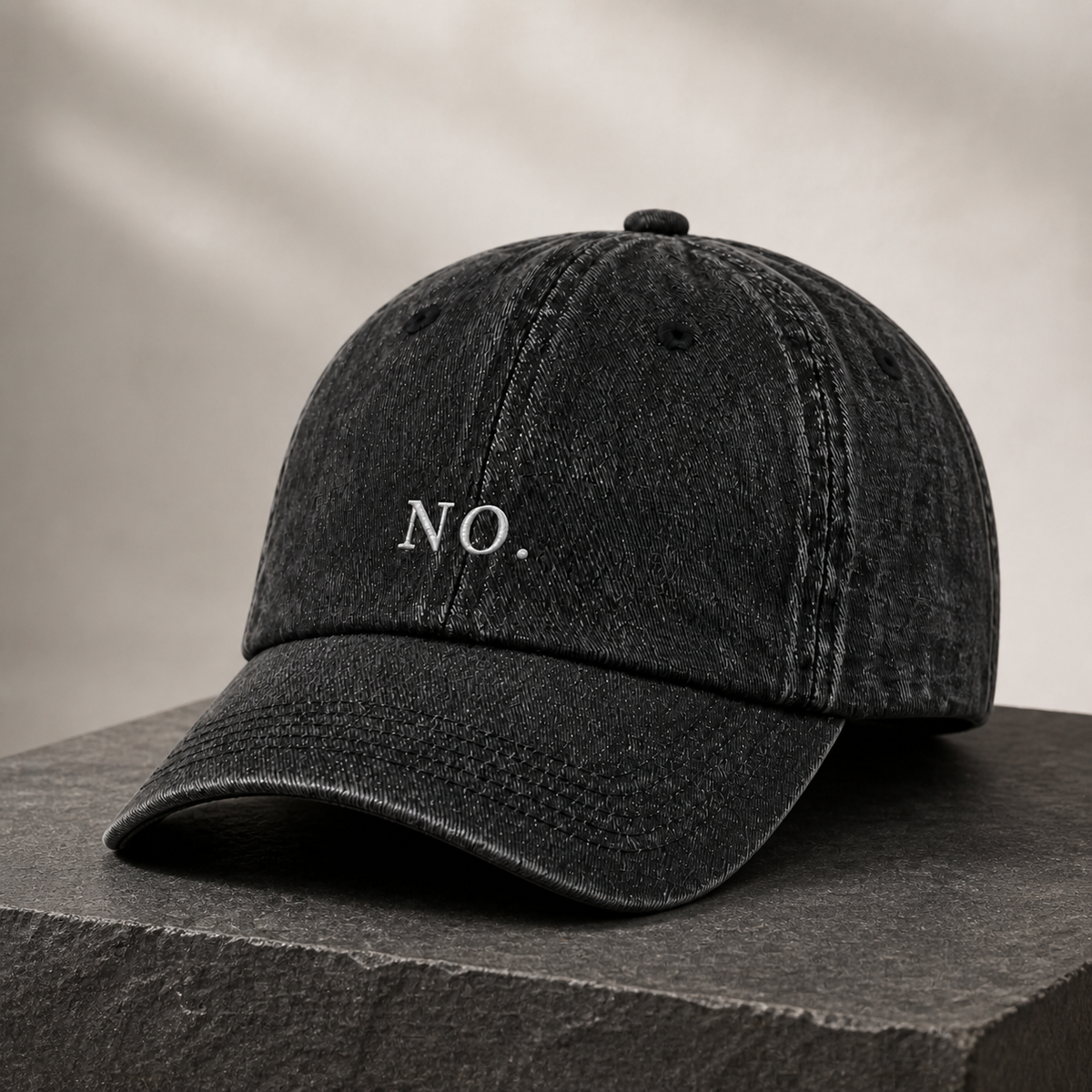 The washed black 'NO.' cap on a dark stone block against a warm plaster backdrop.