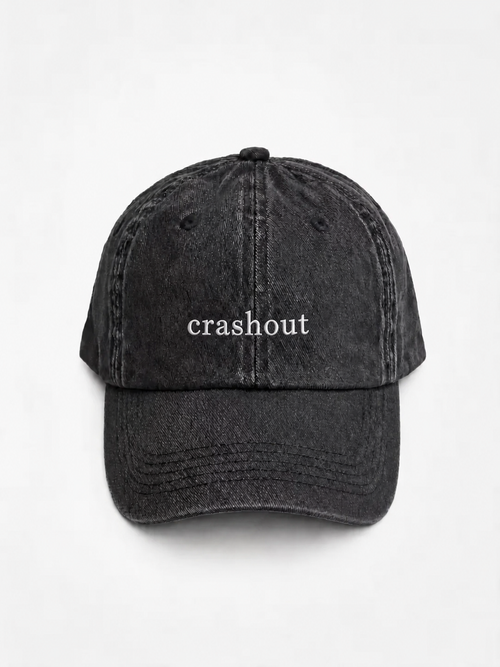 HERO-BLACK Washed black six-panel baseball cap with 'crashout' embroidered in white serif lettering across the front, shown face-on against a plain white background.
