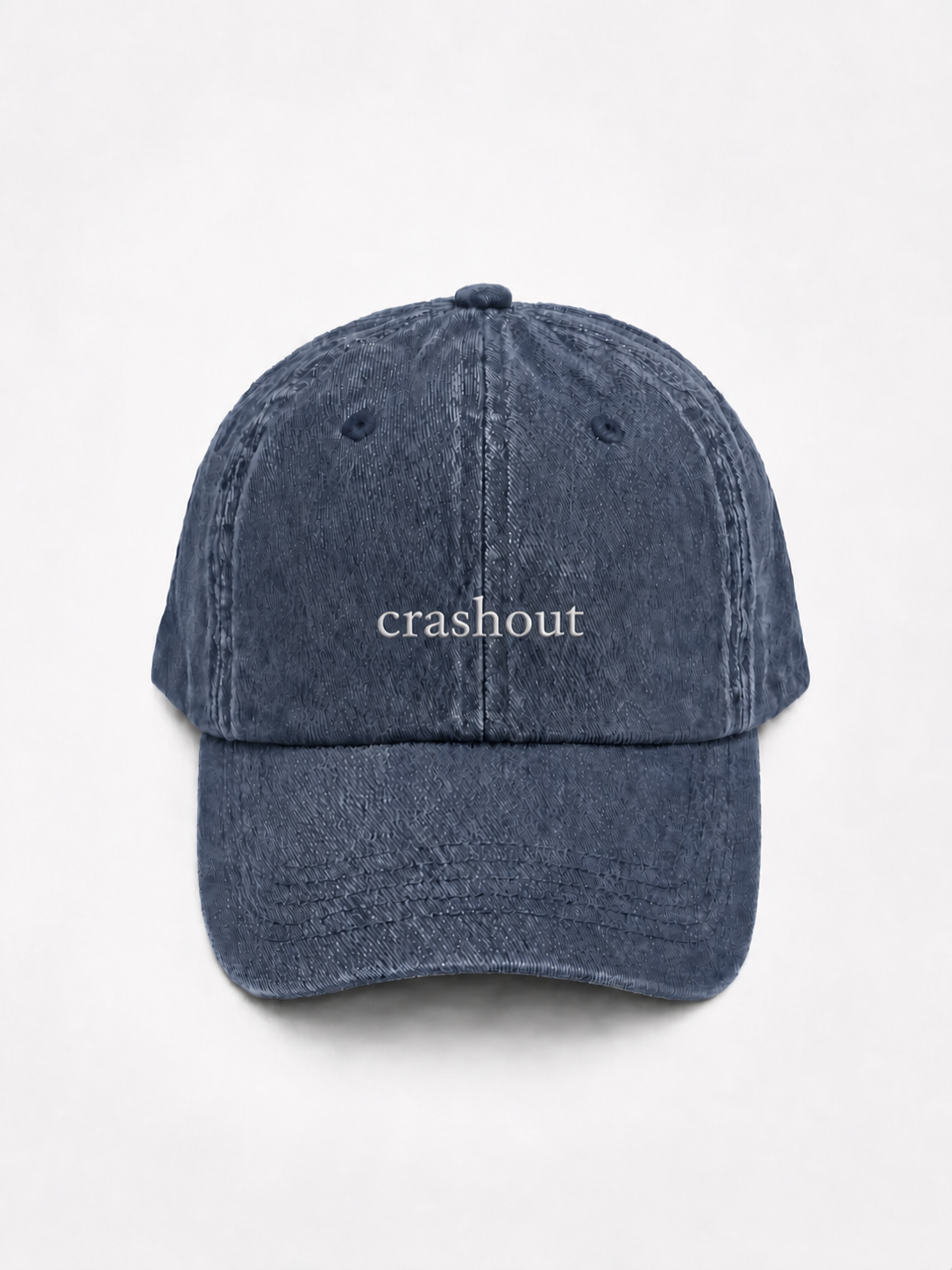 HERO-NAVY Washed navy six-panel baseball cap with 'crashout' embroidered in white serif lettering across the front, shown face-on against a plain white background.