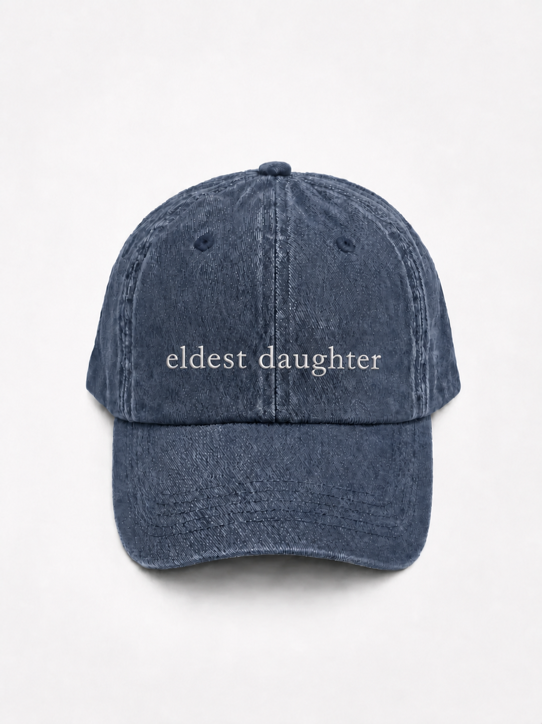 HERO-NAVY Washed navy six-panel baseball cap with 'eldest daughter' embroidered in white serif lettering across the front, shown face-on against a plain white background.