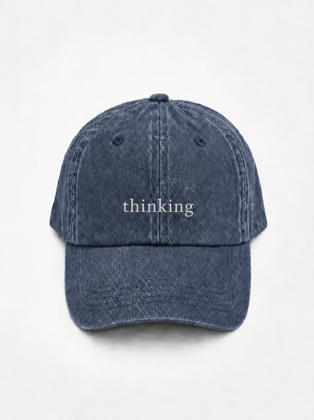 HERO-NAVY Washed navy six-panel baseball cap with 'thinking' embroidered in white serif lettering across the front, shown face-on against a plain white background.