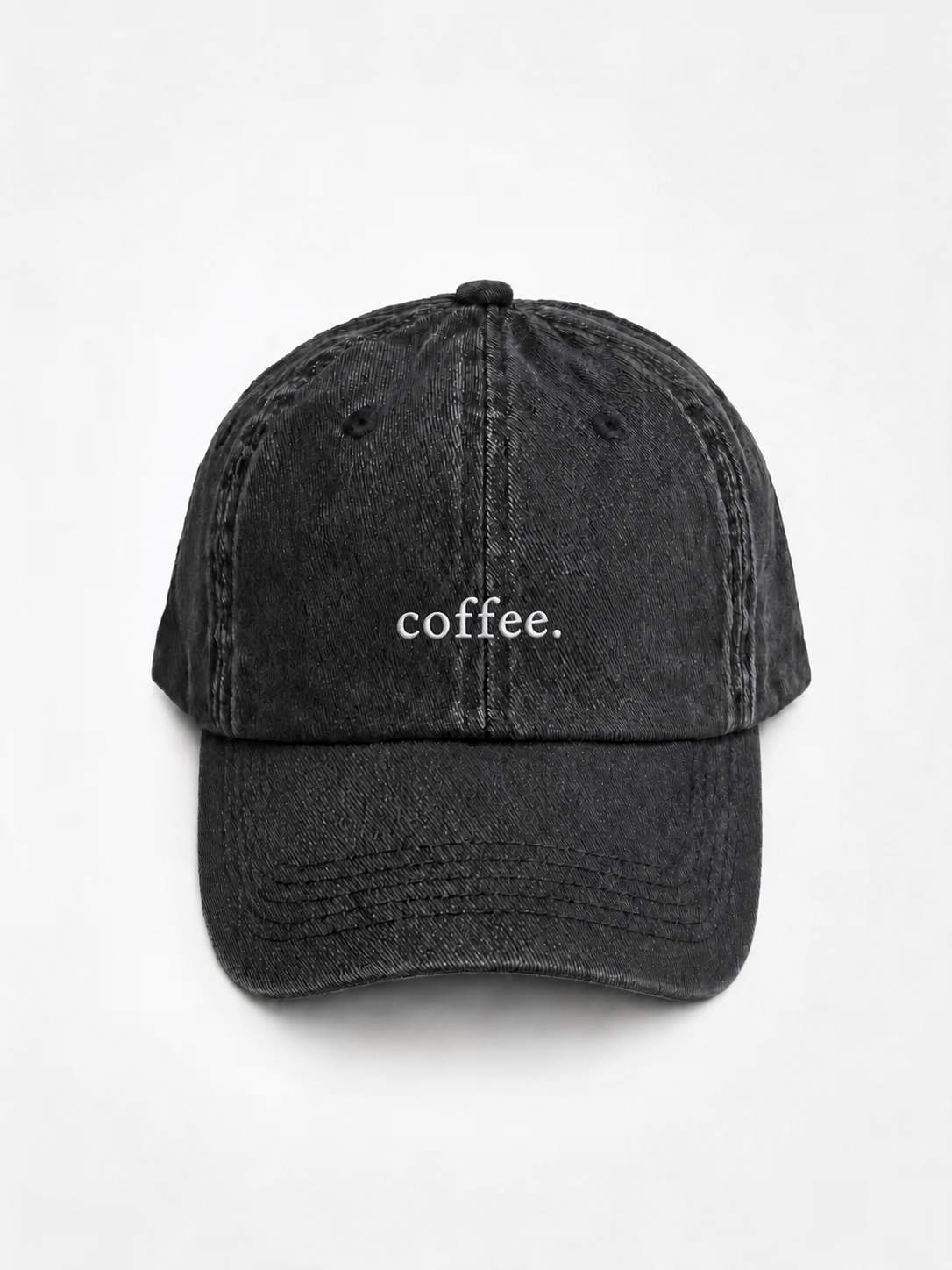 The washed black 'coffee.' cap photographed flat and front-on, showing the white embroidered lettering across the front panel.