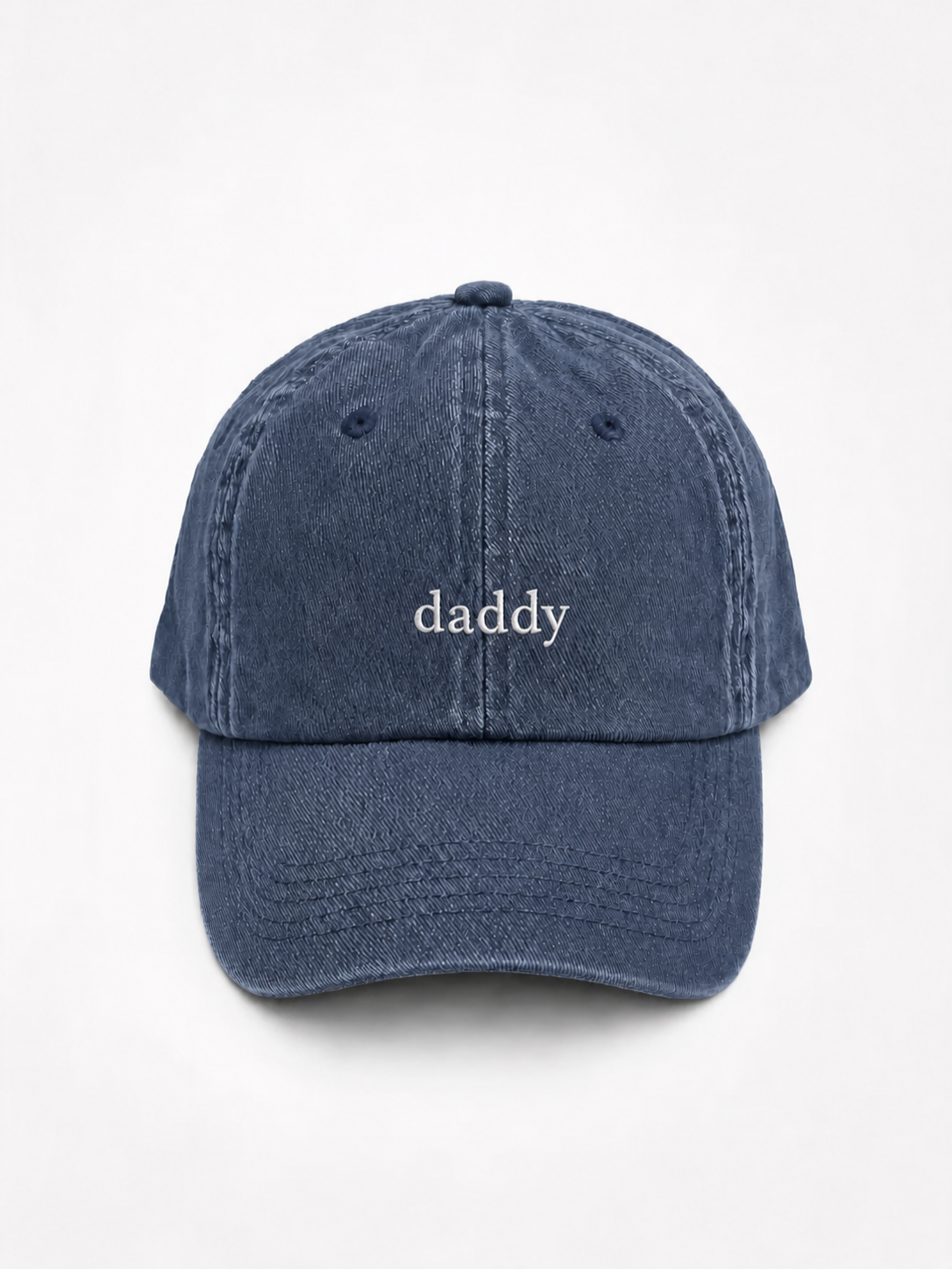 A washed navy blue baseball cap with the word 'daddy' embroidered in white on the front, shown against a plain white background.