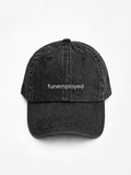 A black washed cotton baseball cap with the word 'funemployed' printed in white lowercase letters on the front, shown against a plain white background.