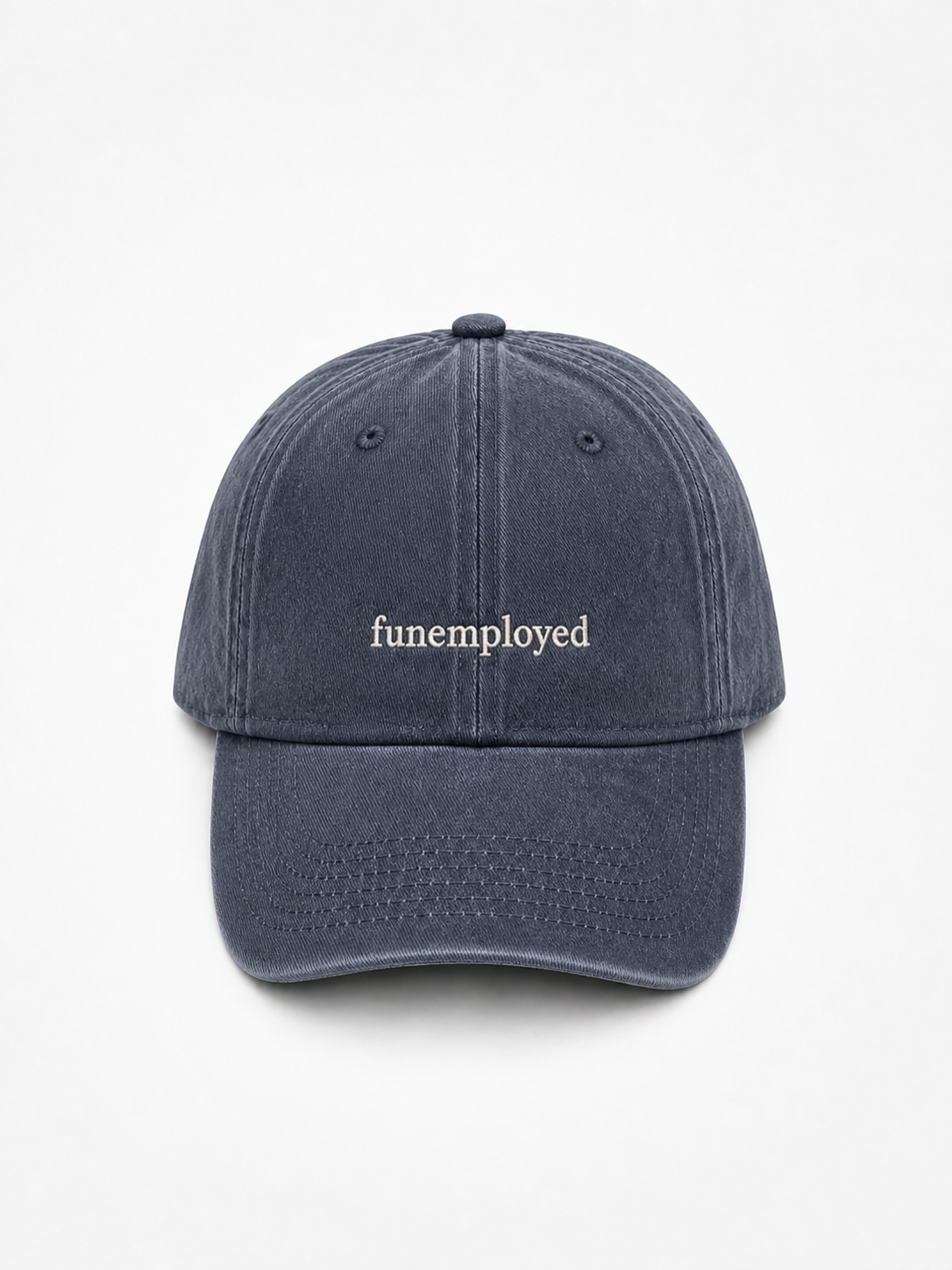 A dark navy blue washed cotton baseball cap with the word 'funemployed' embroidered in white across the front, shown against a plain white background.