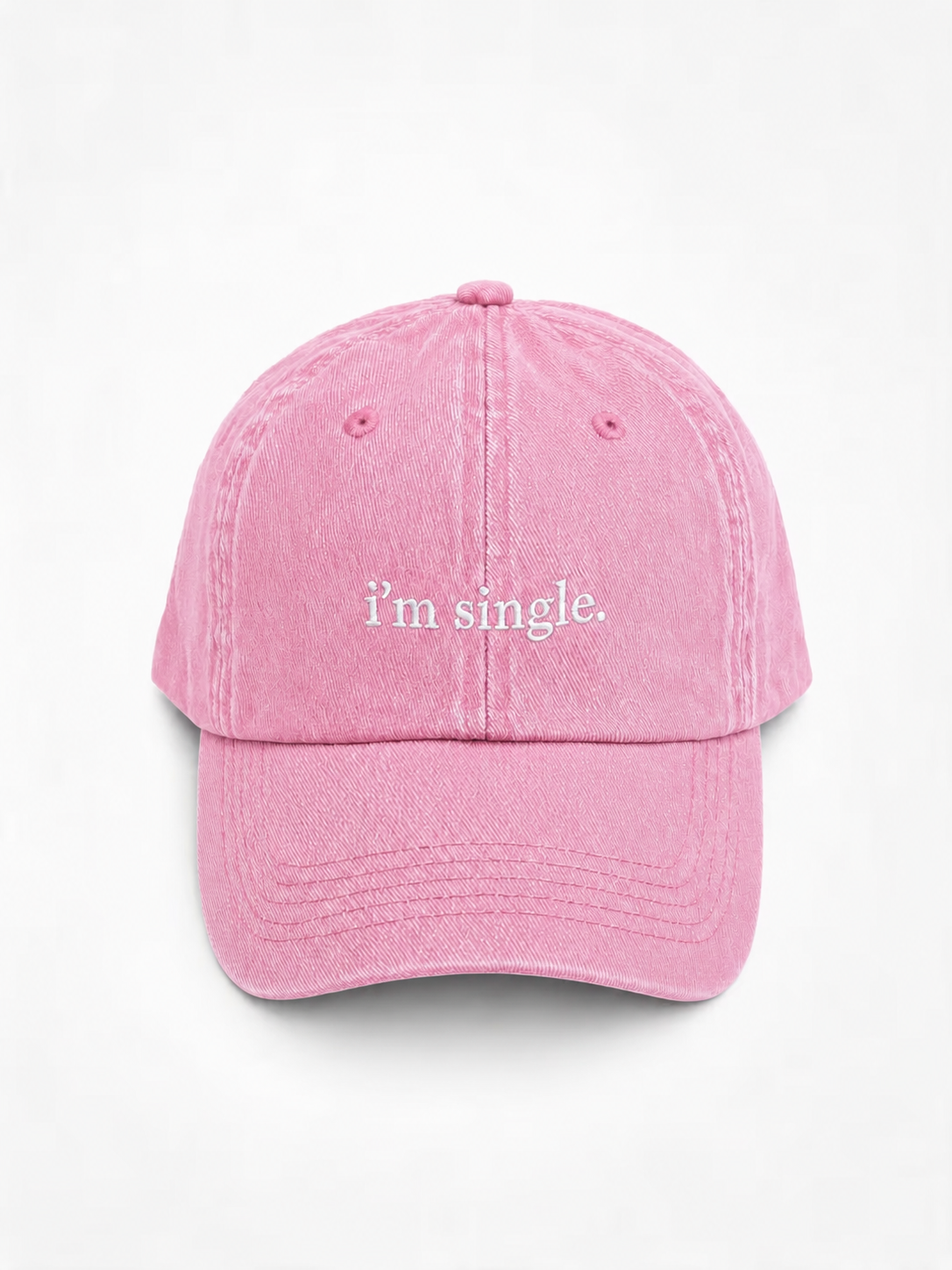 A pink washed cotton baseball cap with the phrase 'i'm single.' embroidered in white script on the front, shown against a plain white background.