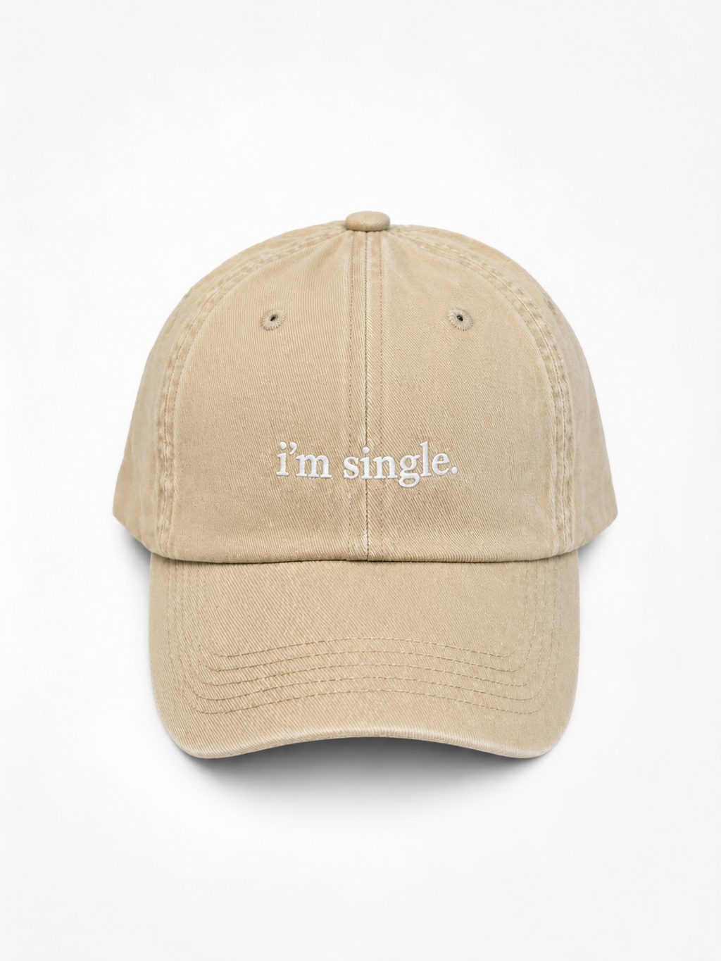 A beige baseball cap with the phrase 'i'm single.' embroidered in white lowercase serif text on the front, shown against a plain white background.