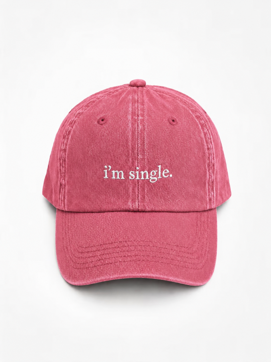 A pink washed cotton baseball cap with the phrase 'i'm single.' embroidered in white script on the front, displayed against a clean white background.