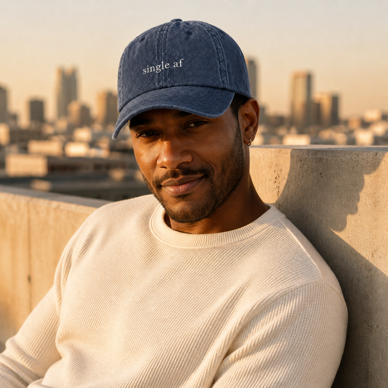 A person wearing a navy baseball cap embroidered with 'single af' in white, standing on a rooftop.