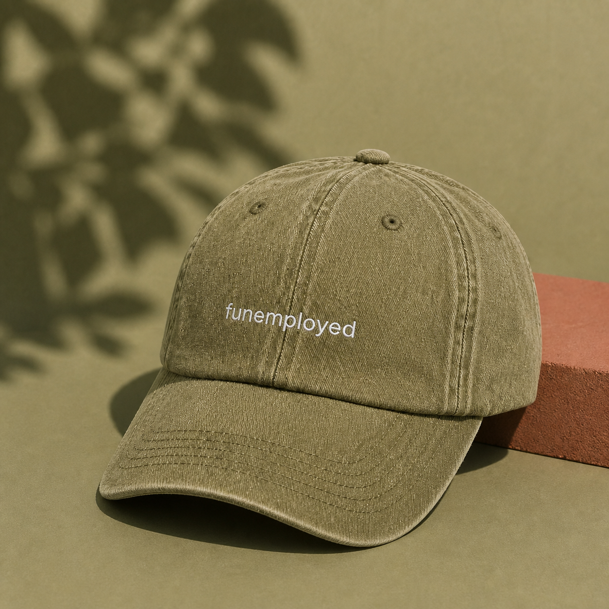 Funemployed cap in olive green — washed cotton dad hat with “funemployed” embroidered in white, product shot