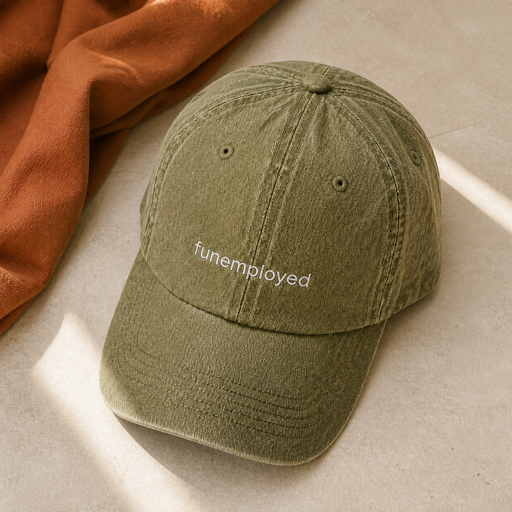 Funemployed cap in olive green — washed cotton dad hat with “funemployed” embroidered in white, product shot