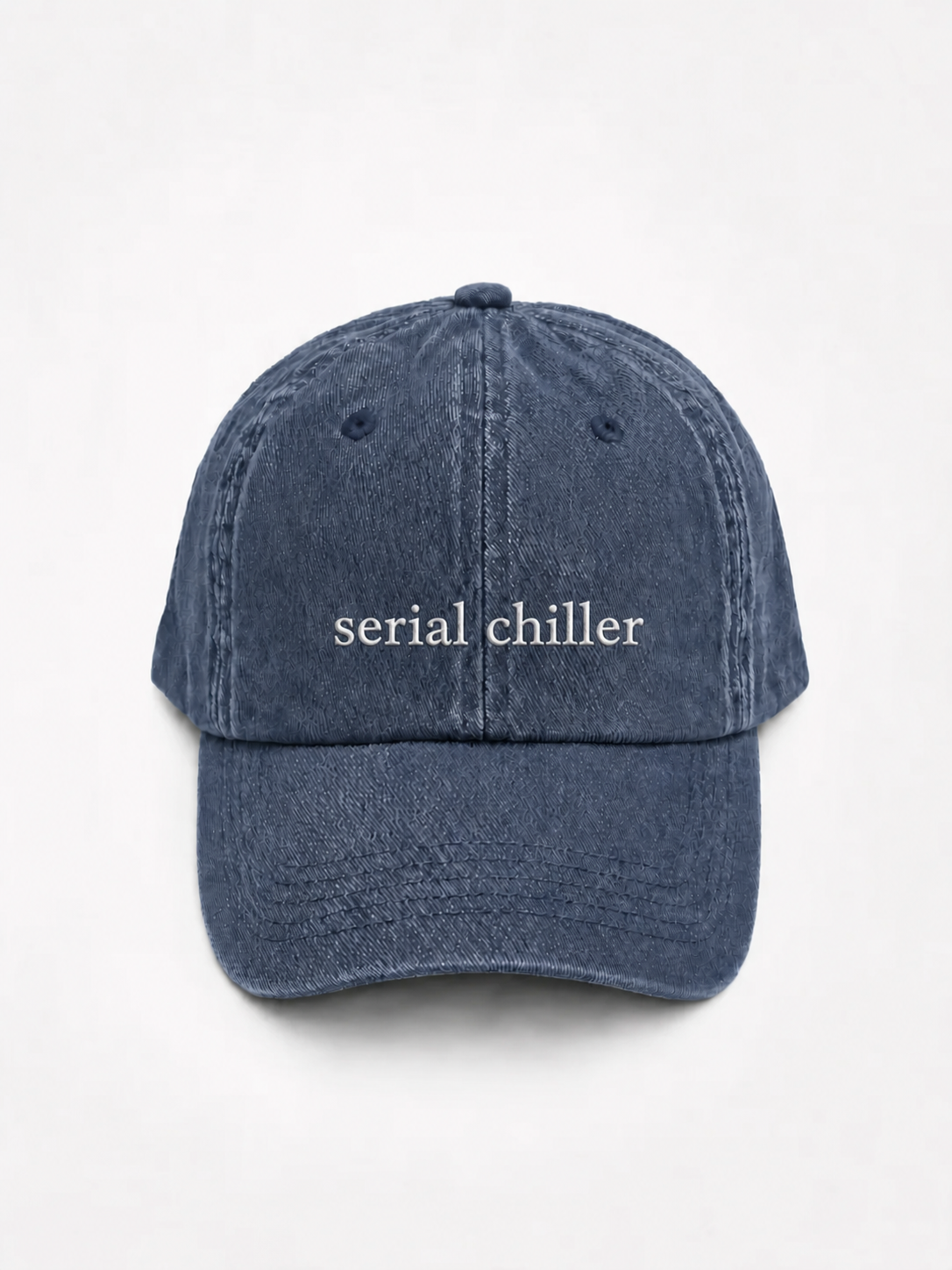 A navy baseball cap embroidered with 'serial chiller' in white, shown from the front against a plain background.